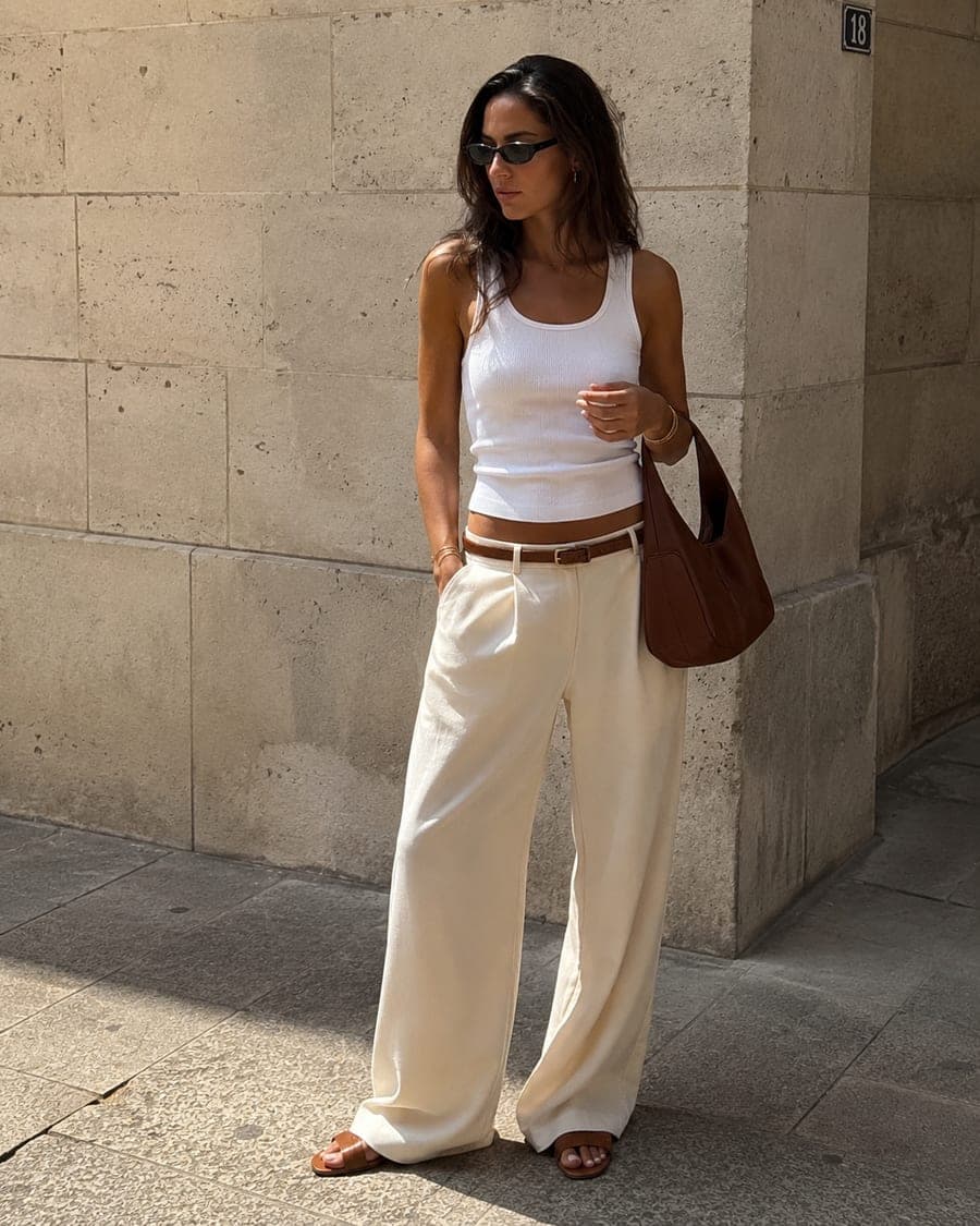 White ribbed tank, cream wide-leg trousers and a brown leather bag — a full outfit